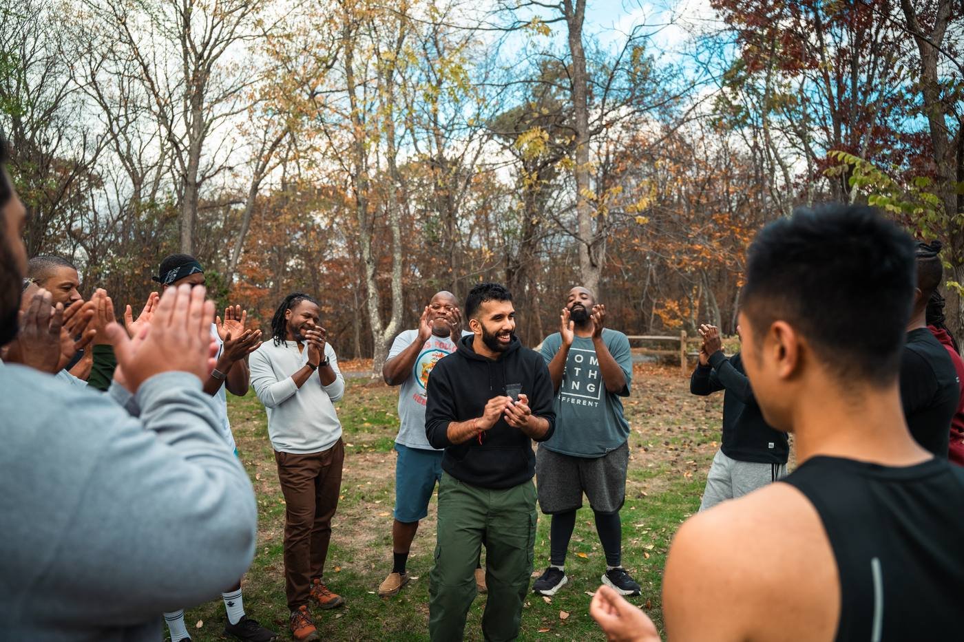 Men clapping in a circle outdoors