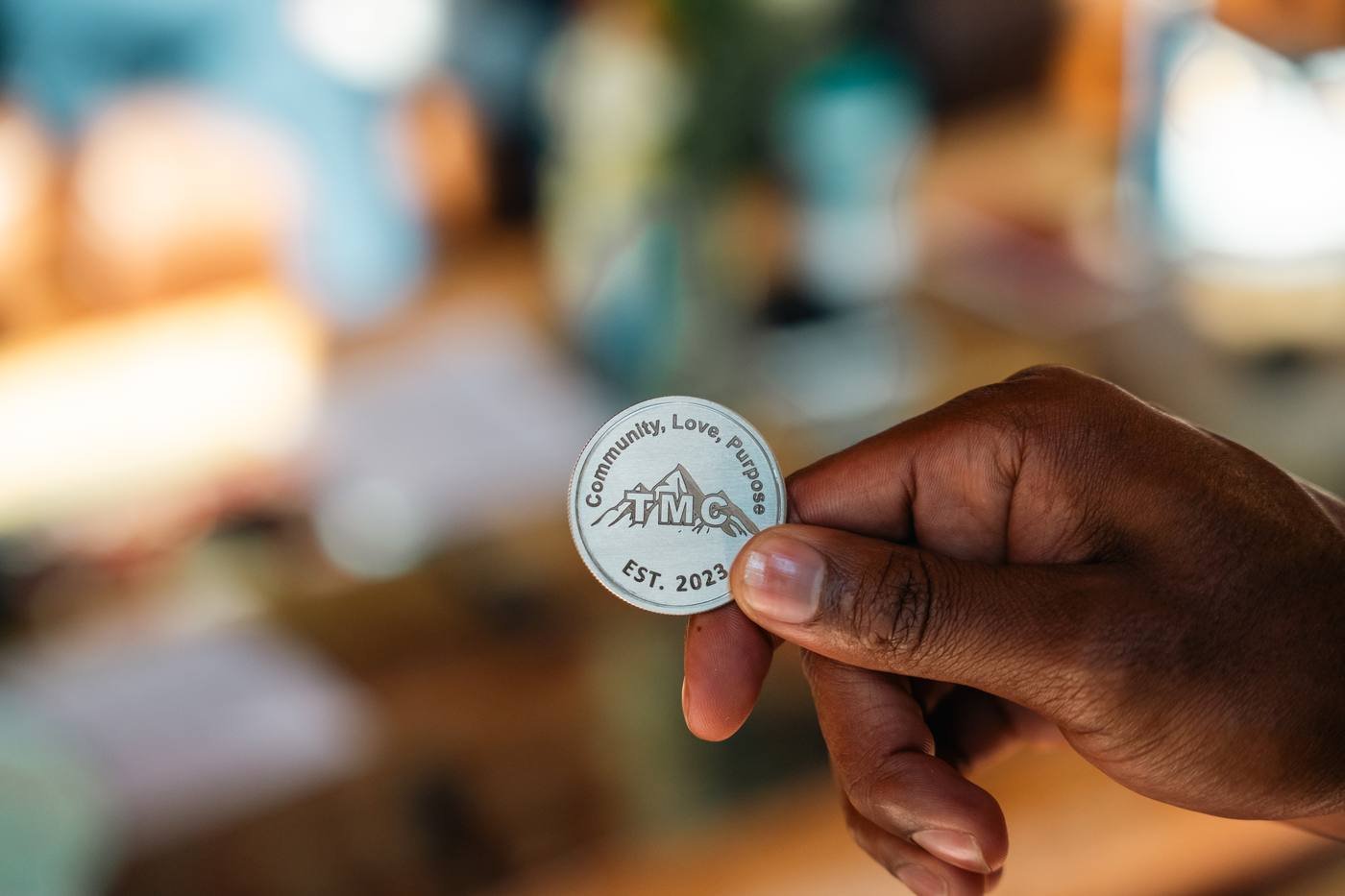 A TMC coin engraved Community, Love, Purpose, Est. 2023