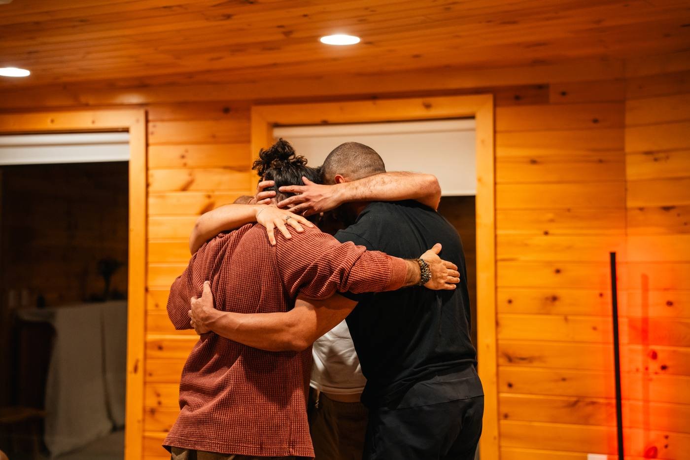 A group of men embracing in a cabin