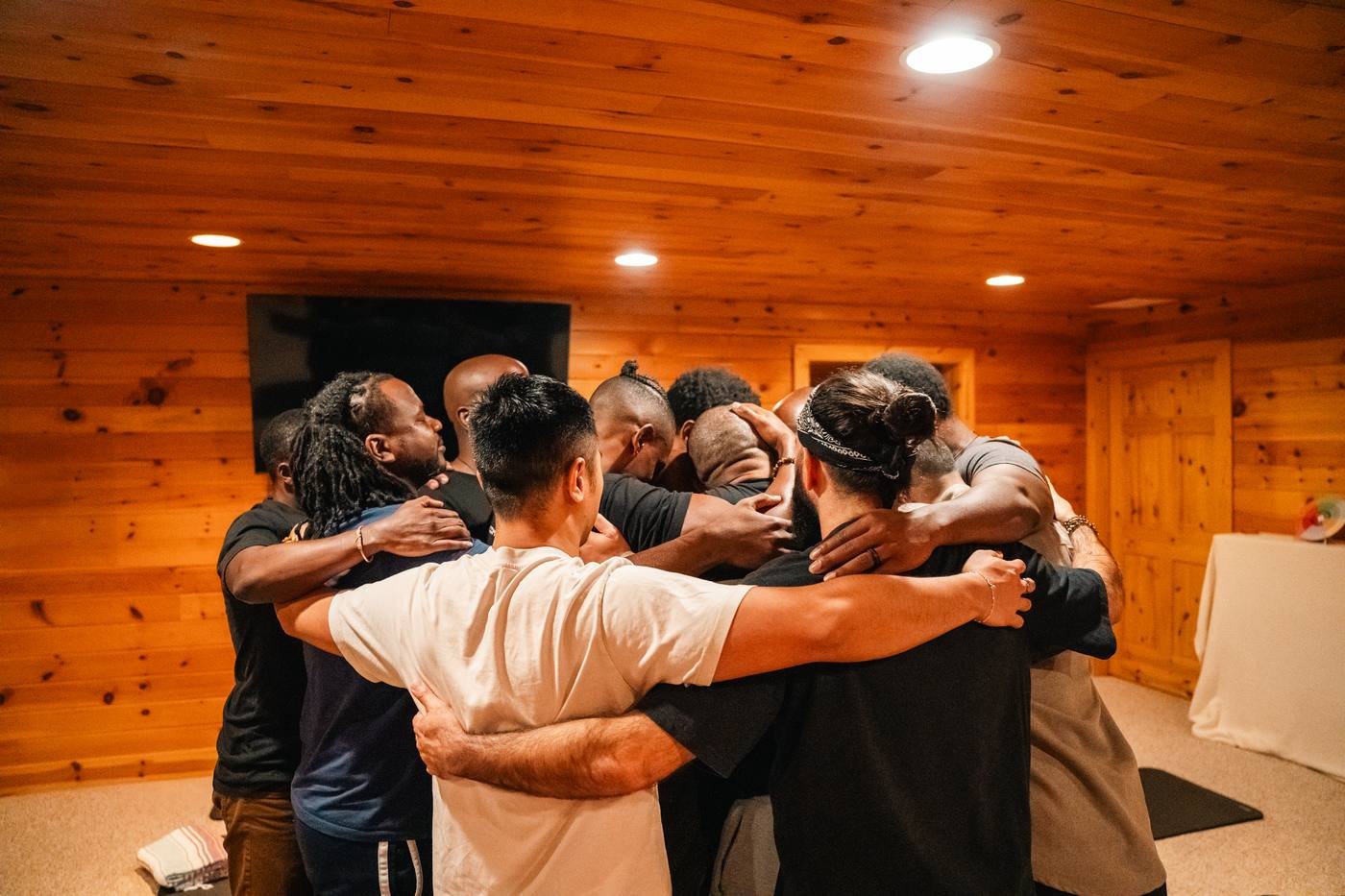 TMC brothers in a tight huddle, arms around one another