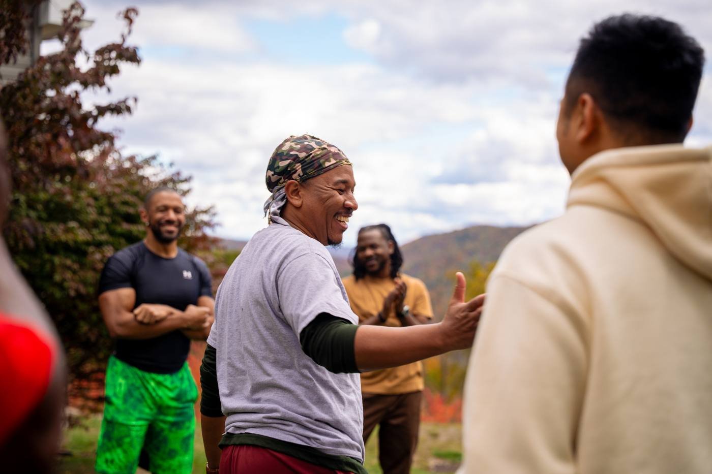 A man laughing with his brothers outdoors