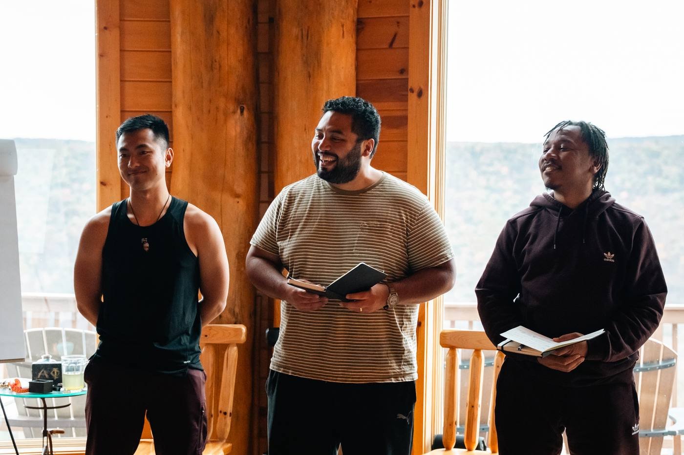 Three men smiling while sharing with the group