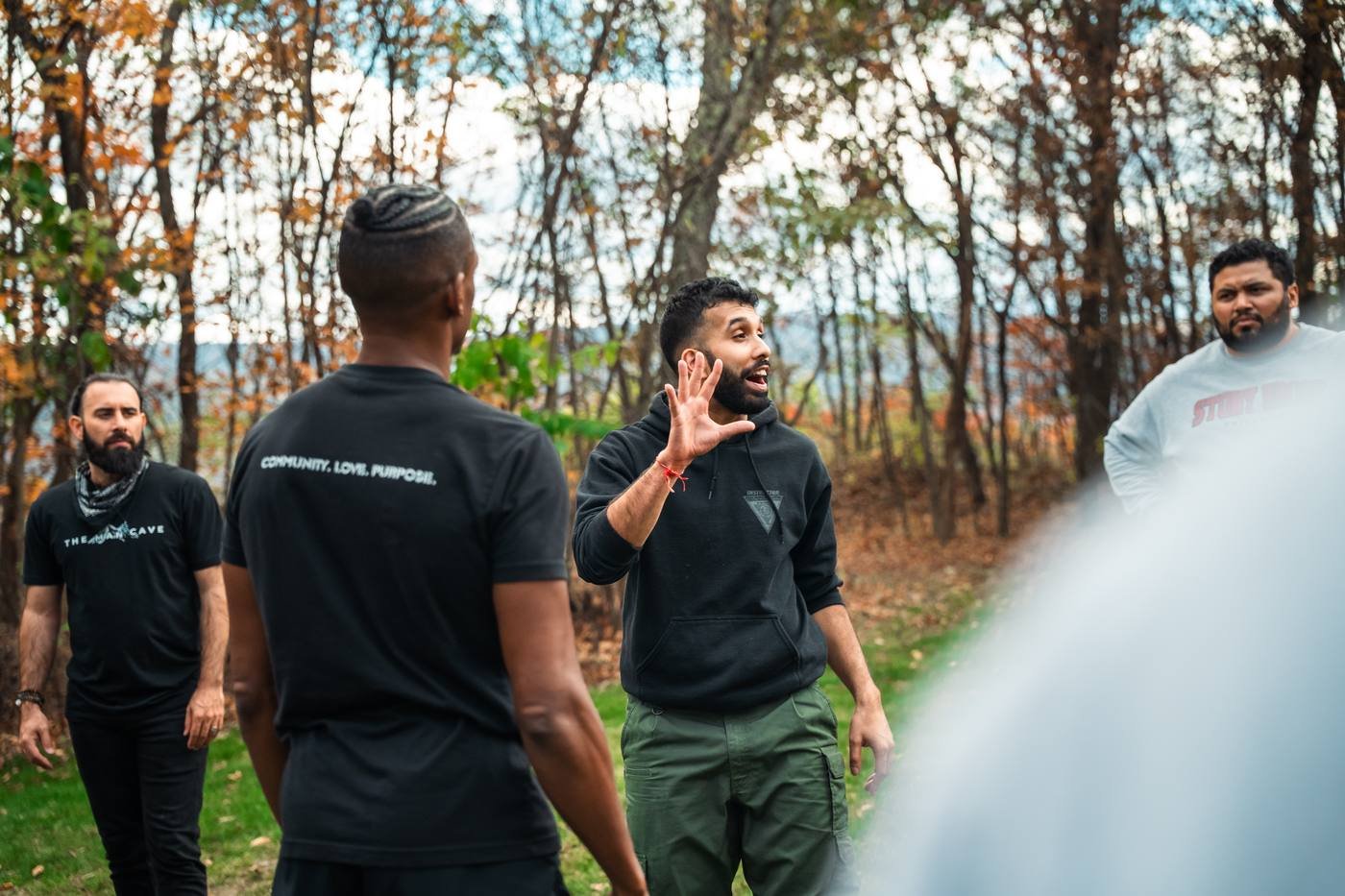 A facilitator speaking to men gathered outdoors